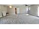 An expansive, gray living room with carpet and ample natural light from rear entry at 6900 W Georgetown Rd, Columbus, IN 47201