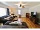 Bright living room with vinyl floors, ceiling fan, and an entertainment center at 6900 W Georgetown Rd, Columbus, IN 47201