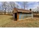 View of the outbuilding on the property with a lush field and sky background at 6900 W Georgetown Rd, Columbus, IN 47201