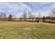 View of the outbuilding on the property with a lush field and sky background at 6900 W Georgetown Rd, Columbus, IN 47201