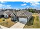 An aerial view of a brick home with a driveway, manicured lawn, and an attached two-car garage at 7326 Wooden Grange Dr, Indianapolis, IN 46259