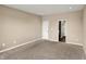 A vacant bedroom with neutral walls, carpet, and a door leading to another room at 7326 Wooden Grange Dr, Indianapolis, IN 46259