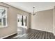 Inviting dining room featuring wood floors, modern light fixture, and a view into the sunroom at 7326 Wooden Grange Dr, Indianapolis, IN 46259