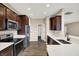 Kitchen with stainless steel appliances, dark wood cabinets, and a view to another room at 7326 Wooden Grange Dr, Indianapolis, IN 46259