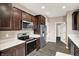 Well-lit kitchen featuring stainless steel appliances and dark wood cabinetry at 7326 Wooden Grange Dr, Indianapolis, IN 46259