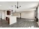 Open living room showcasing a kitchen view, wood floors, stylish lighting, and an inviting space at 7326 Wooden Grange Dr, Indianapolis, IN 46259