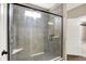 Shower view showcasing its glass door, gray tile, and built-in corner shelves at 7326 Wooden Grange Dr, Indianapolis, IN 46259