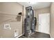 An indoor utility room with water heater, air conditioning, shelving, and modern gray wood plank floors at 7326 Wooden Grange Dr, Indianapolis, IN 46259