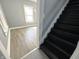 View of dark painted staircase, with view into room with gray walls and floors at 745 W 25Th St, Indianapolis, IN 46208