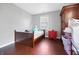 Bedroom with hardwood floors featuring a bed, an armoire, and a window at 821 S Worth Ave, Indianapolis, IN 46241