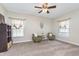 Bright bedroom with soft carpeting, a ceiling fan, and two comfortable chairs by the windows at 8335 S Shady Trail Dr, Pendleton, IN 46064