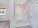 Welcoming foyer with neutral tile flooring, a coat closet, and a view into the carpeted living area at 8335 S Shady Trail Dr, Pendleton, IN 46064