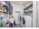 Functional laundry room with washer, dryer, sink, and shelving for storage at 8335 S Shady Trail Dr, Pendleton, IN 46064
