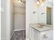 Bathroom with walk-in closet, featuring a granite-look sink, white vanity, and neutral gray walls at 9049 Southernwood Way, Indianapolis, IN 46231