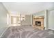 Spacious living room featuring plush carpet, neutral paint, and a cozy fireplace at 9049 Southernwood Way, Indianapolis, IN 46231