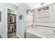 Stylish bathroom with a soaking tub, white tile, and walk-in closet access at 10111 Ironway Dr, Indianapolis, IN 46239