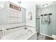 Bright bathroom showcasing a soaking tub, tiled walls, and a glass-enclosed shower at 10111 Ironway Dr, Indianapolis, IN 46239