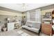 Bedroom with a sewing station, desk, futon, and bright, natural light from a large window at 10111 Ironway Dr, Indianapolis, IN 46239