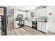 Bright kitchen featuring white cabinets, black appliances, and a window overlooking the yard at 10111 Ironway Dr, Indianapolis, IN 46239