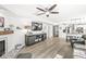 Bright living room with shiplap accent wall, hardwood floors, a ceiling fan, and a decorative fireplace at 10111 Ironway Dr, Indianapolis, IN 46239