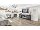 Bright living room with shiplap accent wall, hardwood floors, a ceiling fan, and a decorative fireplace at 10111 Ironway Dr, Indianapolis, IN 46239