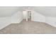 Finished attic space with plush neutral carpeting, and an open doorway leading to a closet at 1026 Jefferson Ave, Indianapolis, IN 46201
