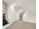 View of the finished attic showing the neutral carpet, the stairwell to the bathroom, and an open doorway with stairs ahead at 1026 Jefferson Ave, Indianapolis, IN 46201