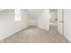 The finished attic showing the neutral carpet, window, an open doorway, and access to other rooms at 1026 Jefferson Ave, Indianapolis, IN 46201