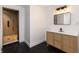 Bathroom featuring modern vanity with woven doors, black hexagon tile floor, and a glass-enclosed shower with wood look tile at 1026 Jefferson Ave, Indianapolis, IN 46201