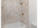Tiled bathtub shower combo featuring vertical tiling and bronze hardware at 1026 Jefferson Ave, Indianapolis, IN 46201