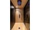 Shower stall showcasing wood-look vertical tile, black fixtures, rainfall shower head, and black hexagon tiled walls at 1026 Jefferson Ave, Indianapolis, IN 46201
