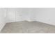 Finished attic space featuring plush neutral carpeting, white walls, window, and white painted door and trim at 1026 Jefferson Ave, Indianapolis, IN 46201