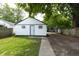 White exterior garage featuring a small door for entering, with yard at 1026 Jefferson Ave, Indianapolis, IN 46201