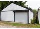 White garage featuring a large door for car entrance, with side yard at 1026 Jefferson Ave, Indianapolis, IN 46201