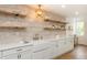 Stylish kitchen featuring a farmhouse sink, quartz countertops, and floating wood shelves at 1026 Jefferson Ave, Indianapolis, IN 46201
