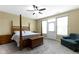 Spacious bedroom with a four-poster bed, ceiling fan, private entry, and cozy sitting area at 10451 Meadow Lake Dr, Fishers, IN 46038
