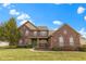 Lovely two-story brick home featuring a well-kept lawn, mature landscaping, and inviting front porch area at 10451 Meadow Lake Dr, Fishers, IN 46038