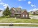 Beautiful two-story brick home with a well-manicured lawn, lush landscaping, and an inviting entrance at 10451 Meadow Lake Dr, Fishers, IN 46038