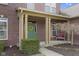 Inviting green front door with a yellow wreath, set within a classic brick facade and cozy front porch setting at 10451 Meadow Lake Dr, Fishers, IN 46038
