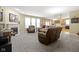 Cozy living room with fireplace, large windows, comfortable seating, and carpet at 10451 Meadow Lake Dr, Fishers, IN 46038