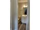 Bathroom with white vanity, view to stairway, and wood-look floors at 10622 Howe Rd, Fishers, IN 46038