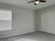 This bedroom is well-lit, featuring a ceiling fan and a large window at 10622 Howe Rd, Fishers, IN 46038
