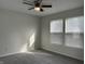 Neutral carpeted bedroom featuring a ceiling fan and natural light from a large window at 10622 Howe Rd, Fishers, IN 46038