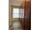 Hallway with wood-look floors, window, and long cabinet offering ample storage space at 10622 Howe Rd, Fishers, IN 46038