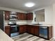 Kitchen featuring stainless steel appliances, wood cabinets, and eat-in bar at 10622 Howe Rd, Fishers, IN 46038