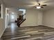 Spacious living room with wood-look floors, an open staircase, and lots of natural light at 10622 Howe Rd, Fishers, IN 46038