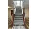 Carpeted staircase with wood banister and wrought iron spindles leads to the upper level at 10622 Howe Rd, Fishers, IN 46038