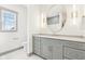 Modern bathroom with light-grey vanity, round mirror, and natural light at 10756 Dartmoor Way, Zionsville, IN 46077