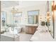 This spacious bathroom has a glass shower, a soaking tub, and double vanities with quartz counters at 10756 Dartmoor Way, Zionsville, IN 46077