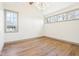 Empty bedroom features hardwood floors, bright windows, and modern light fixture at 10756 Dartmoor Way, Zionsville, IN 46077